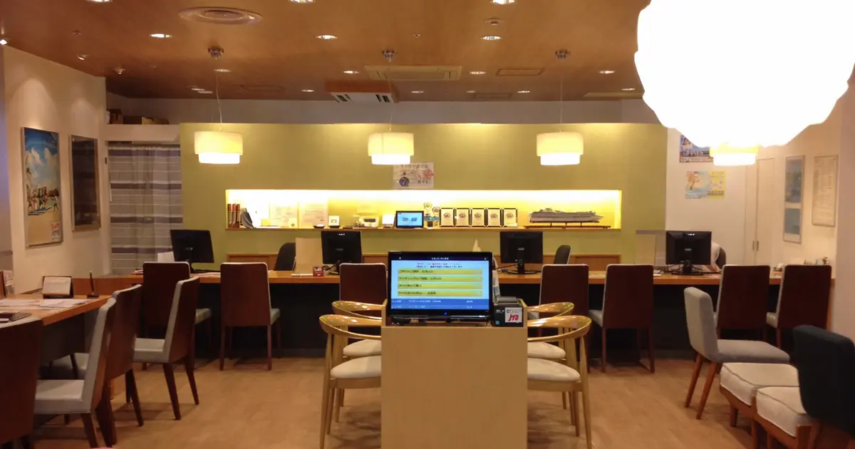 大手旅行代理店の札幌カウンターに設置されたアイリスト — モニター付きスタンドで順番待ちを管理