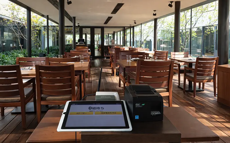 アイリスト設置風景 — 飲食店の受付カウンターに設置されたタブレット端末とプリンター