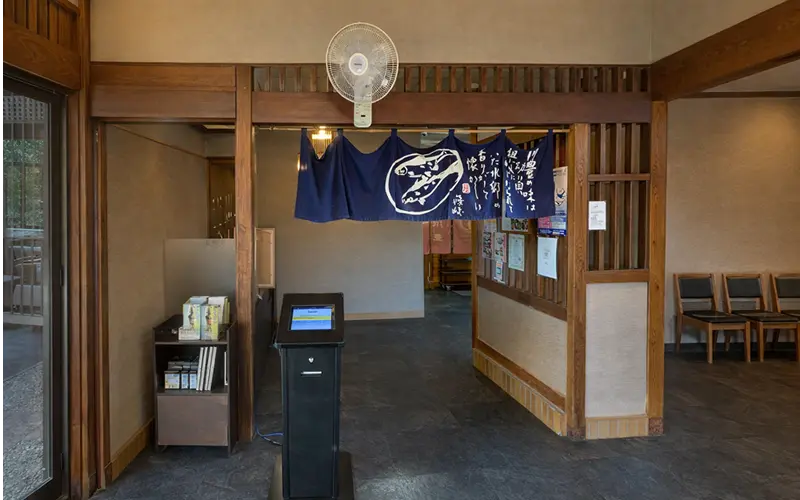 アイリスト設置風景 — 店舗入口に設置されたスタンド型受付端末